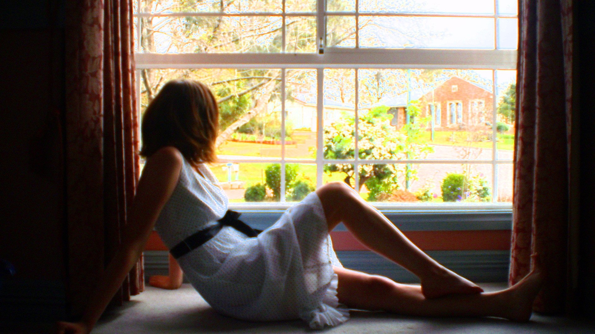 Девушка в одних трусиках стоит у панорамного окна фото