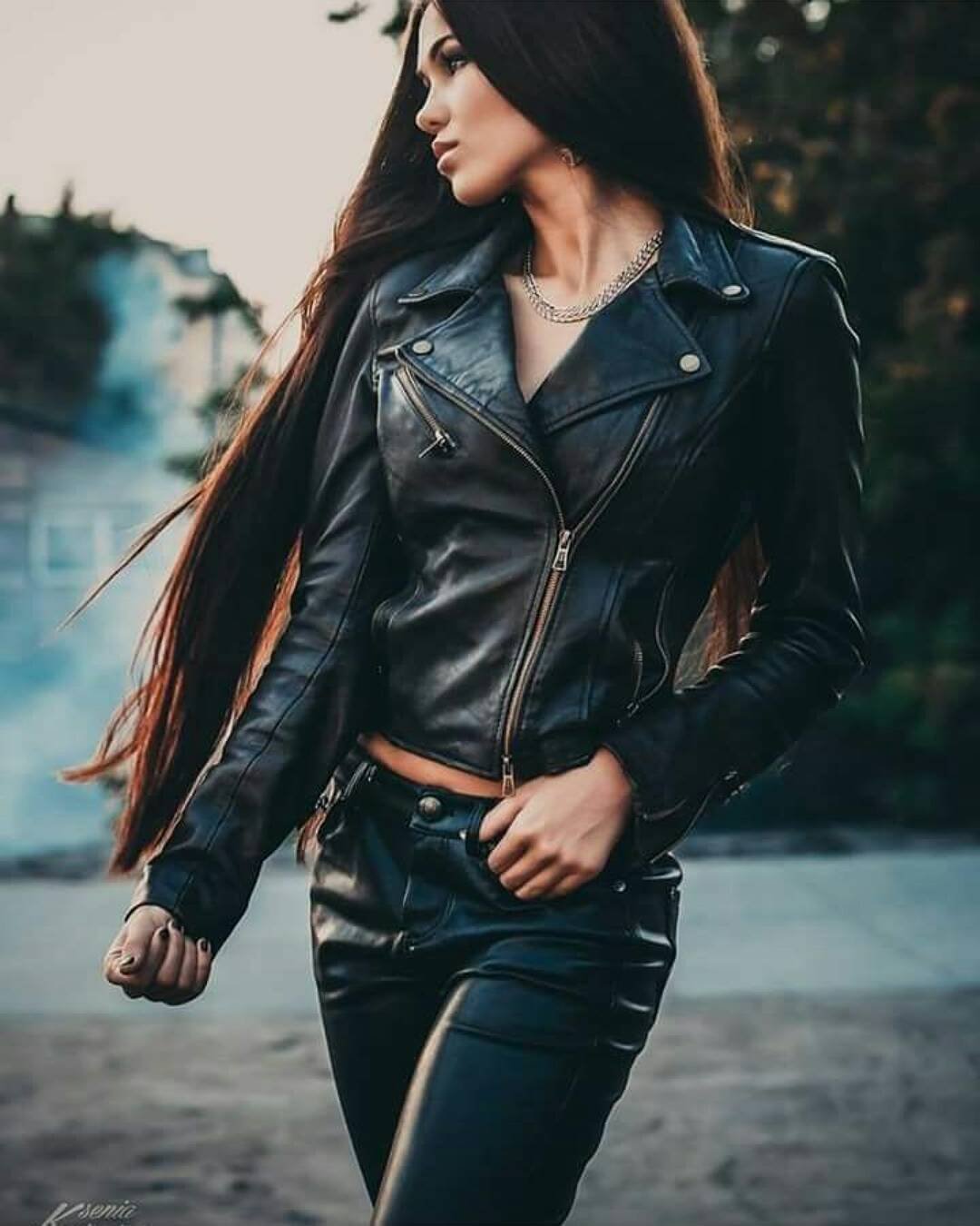 Девушка с длинными черными волосами снимает кожаную куртку