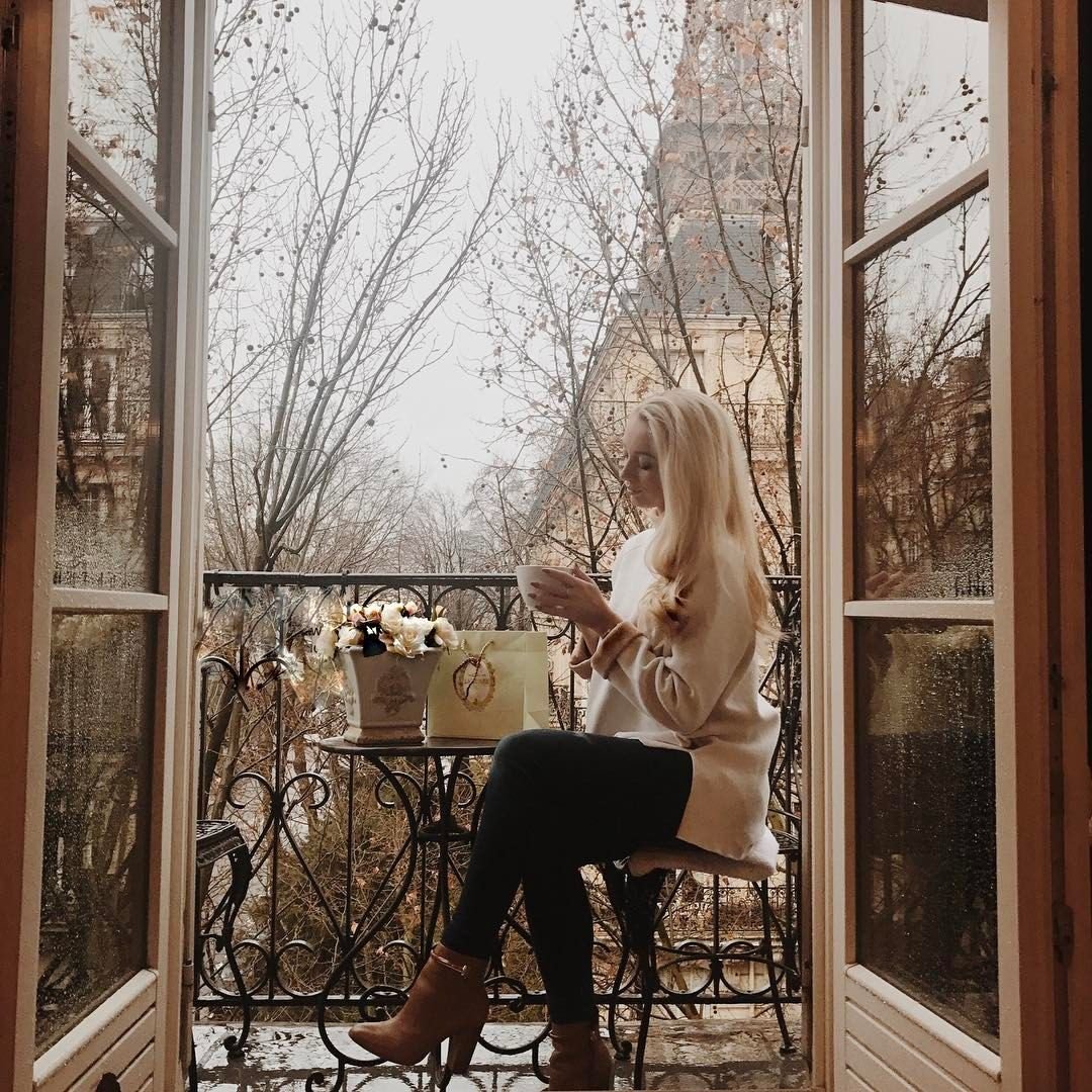 Девушка с чашкой кофе у окна