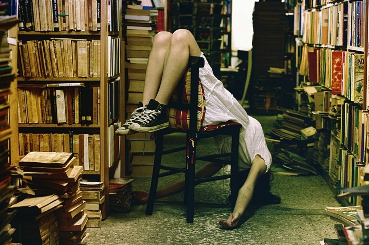 Она сидит в библиотеке. Девушка с книгой. Фотосессия с книгой. Девочка в библиотеке. Девушка с книжкой.