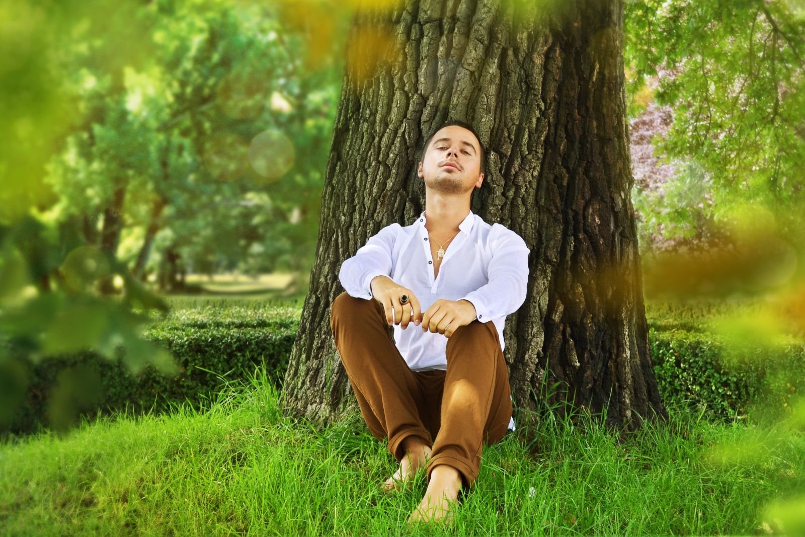 Расслабленный голос. Человек и природа. Человек сидит на траве. Мужчина на природе. Спокойный человек.