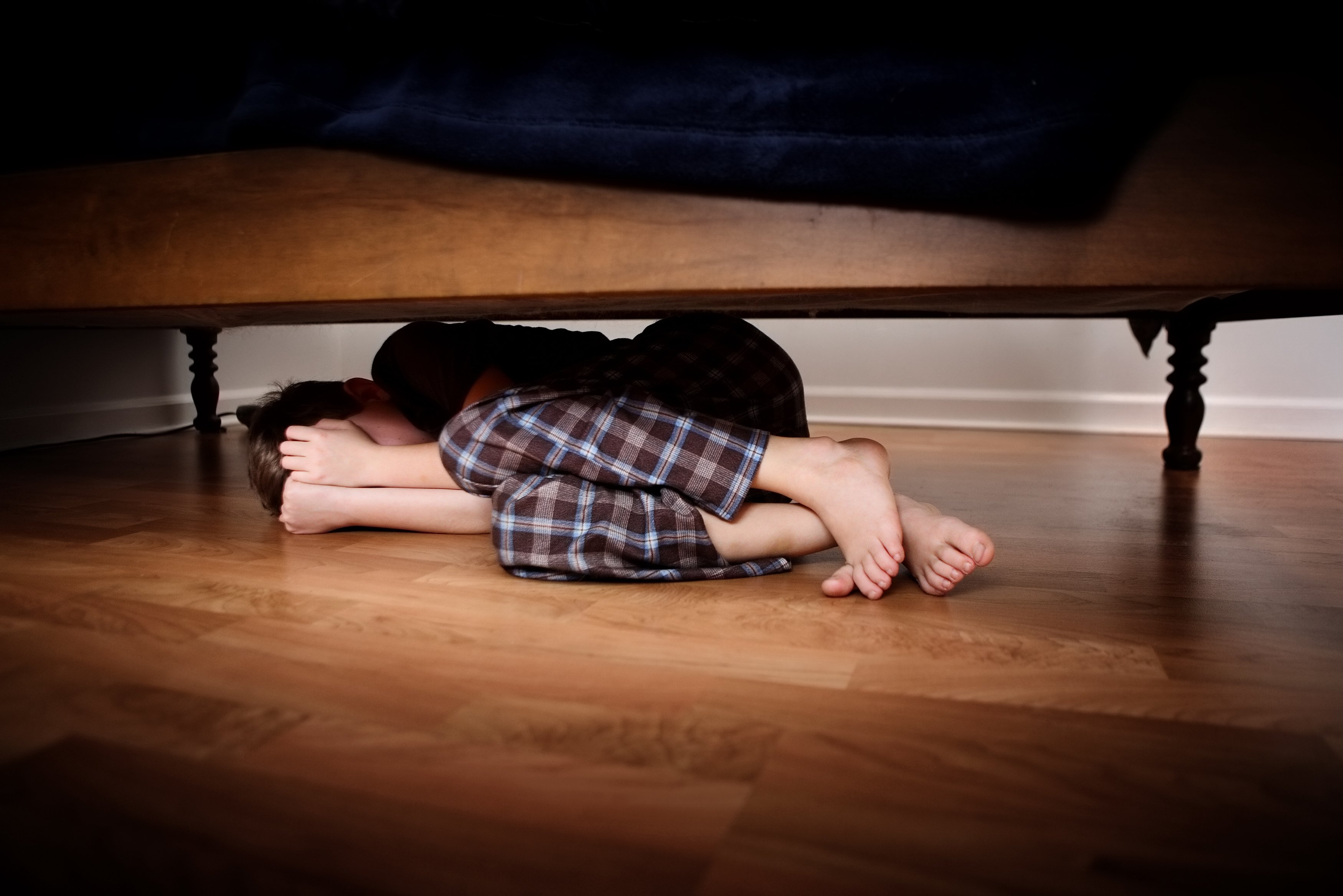 Hid under the bed. Прячется под кроватью. Спрятался под кровать. Человек под столом.