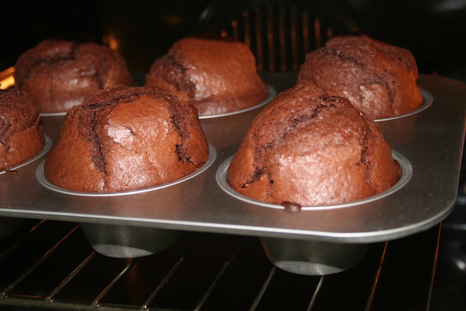 Печь кекс шоколадный. Шоколадный кекс в духовке. Маффины шоколадные в духовке. Готовый кекс в духовке. Шоколадные кексы в духовке в формочках.