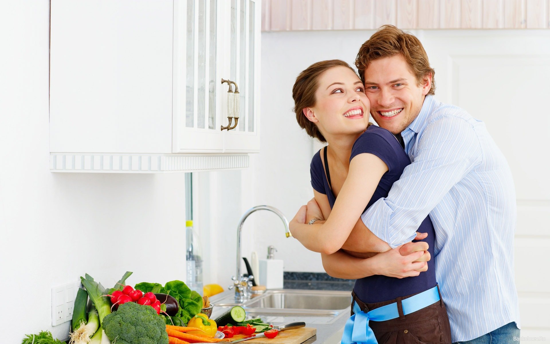 Хорошо посмотрим вместе. Мужчина и женщина на кухне. Счастливая пара на кухне. Счастливая женщина на кухне.
